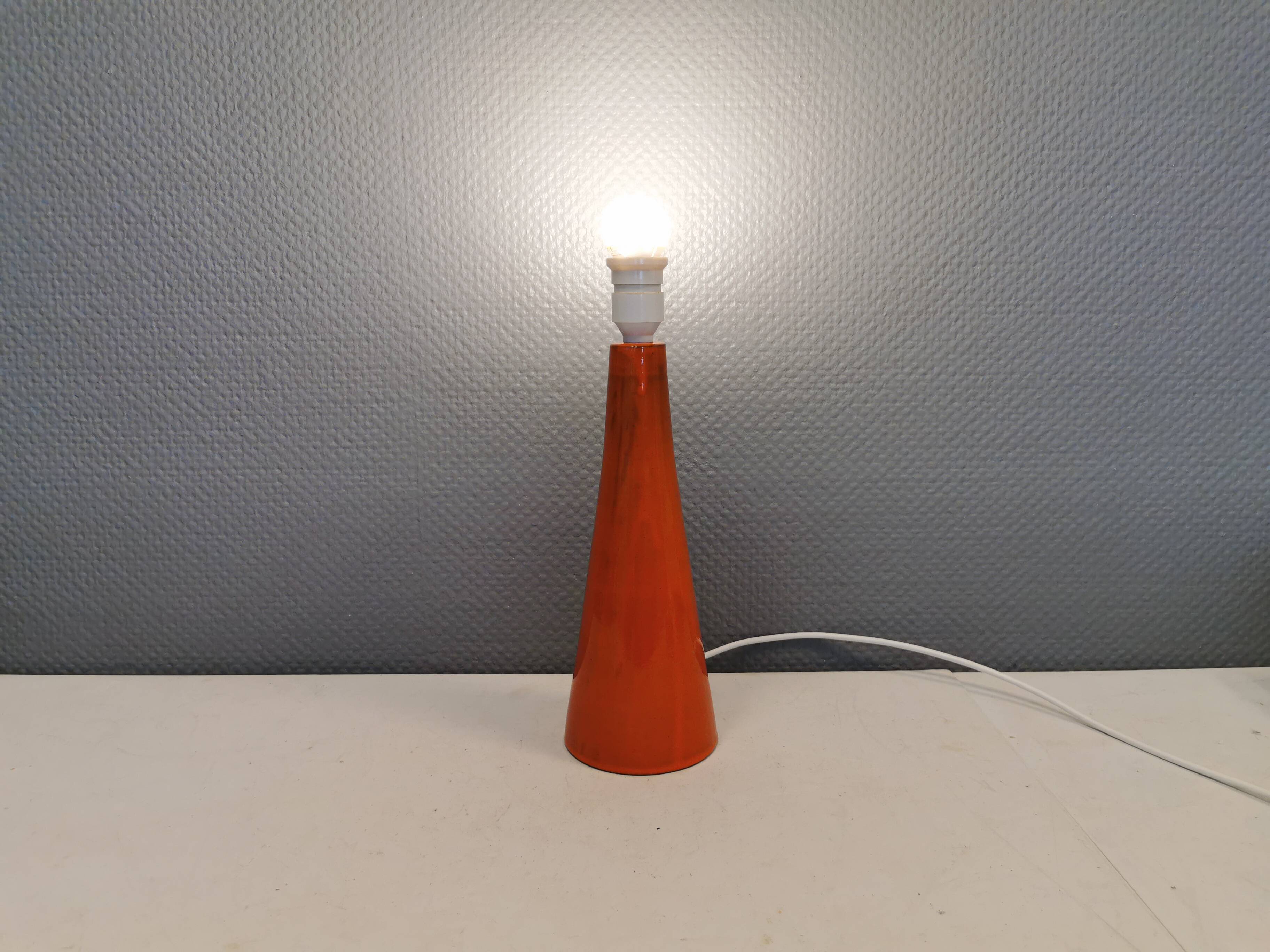 Ceramic table lamp with partial orange glaze.