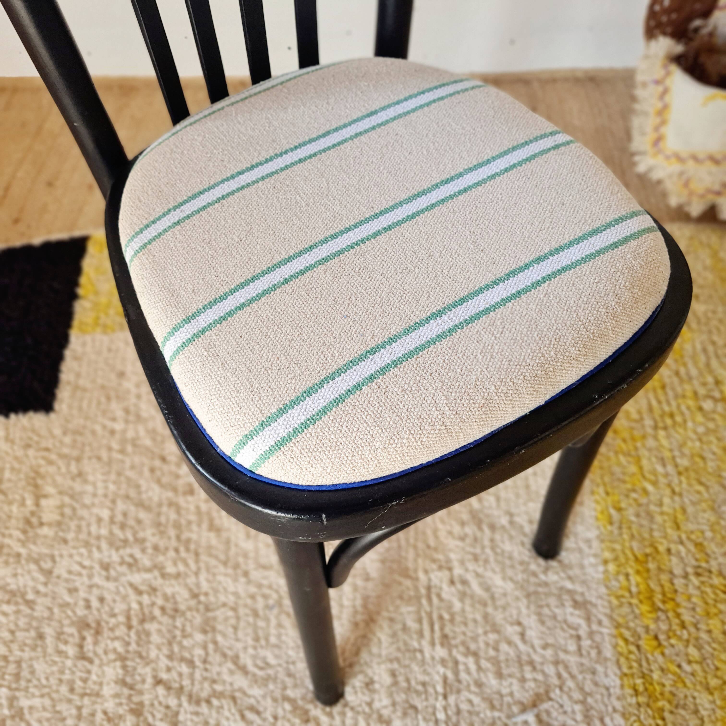 Curved black wooden bistro chair with striped seat