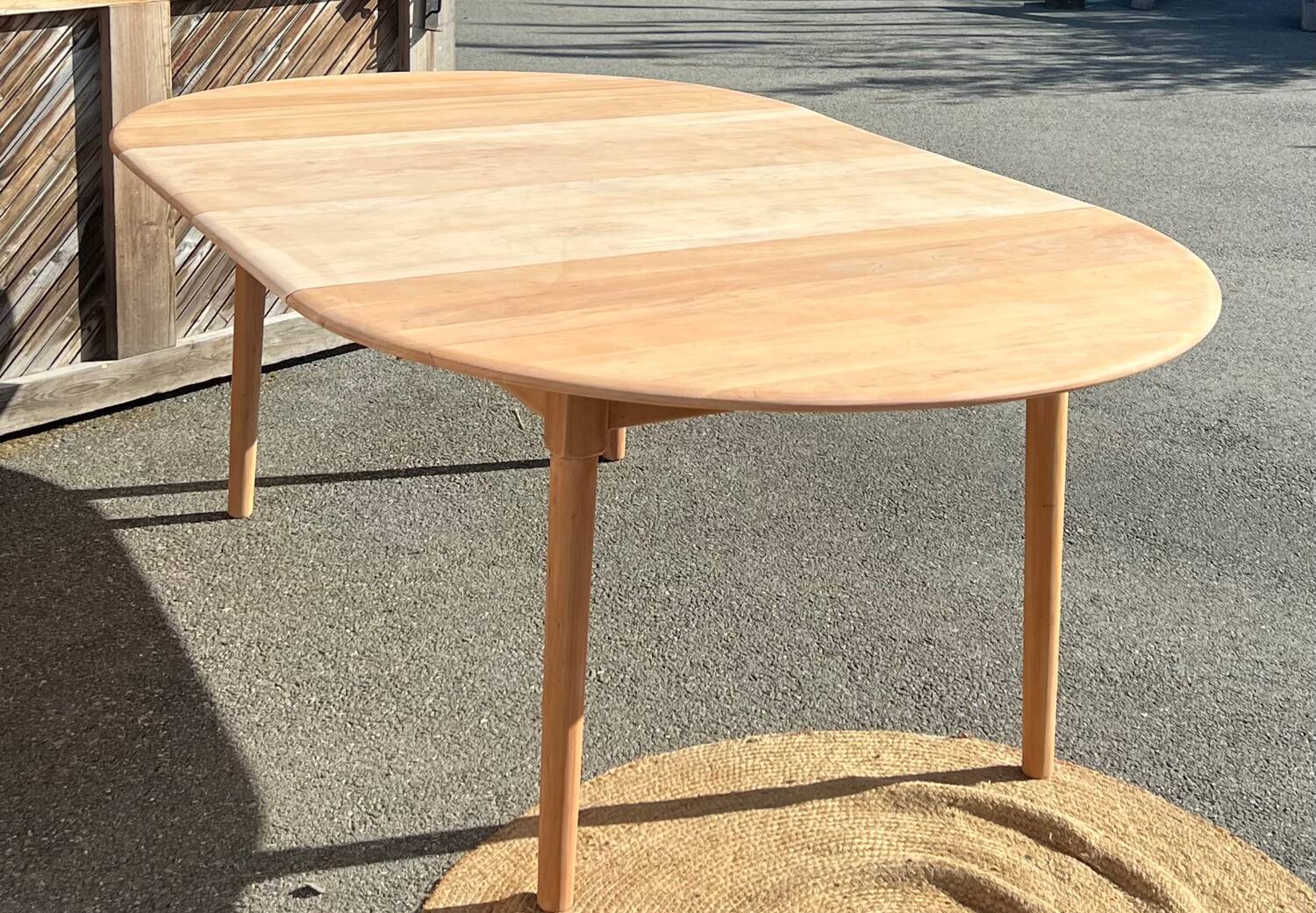 Large round family table with 2 extensions in solid raw wood.