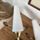 Pair of wall sconces in brass with white glass tulips.