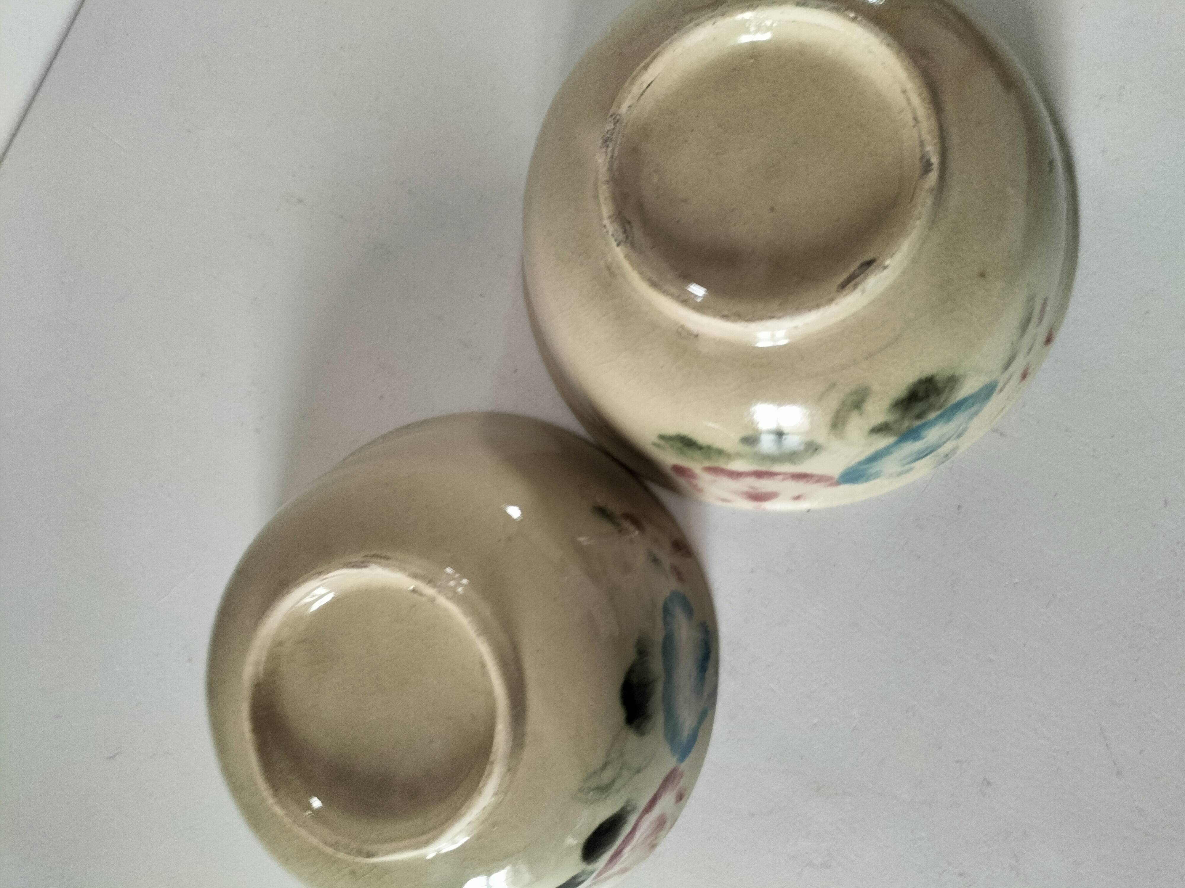 Two large vintage bowls in pastel decor on mini pedestals.