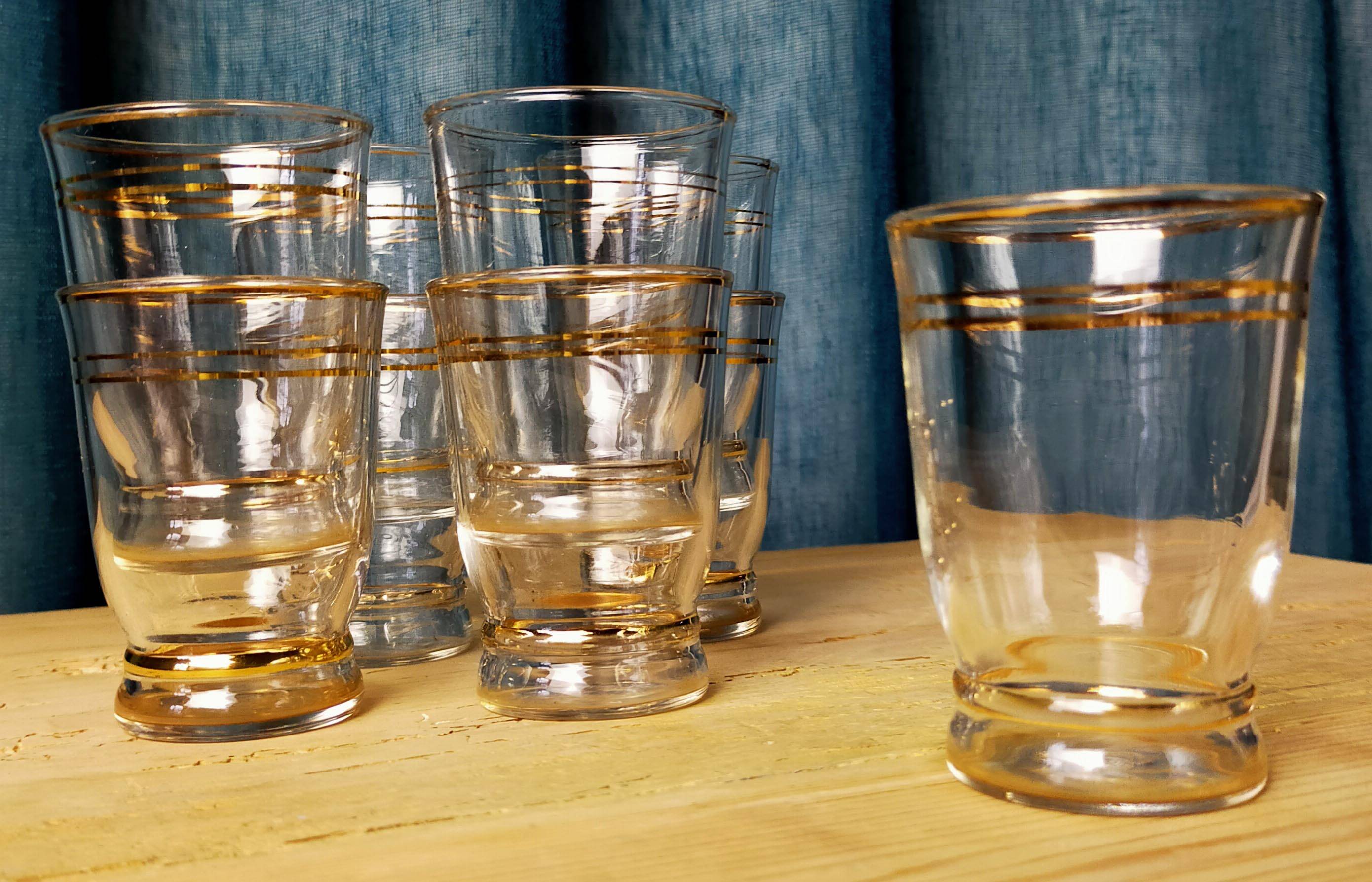 Set of 9 antique glasses with gold rim.
