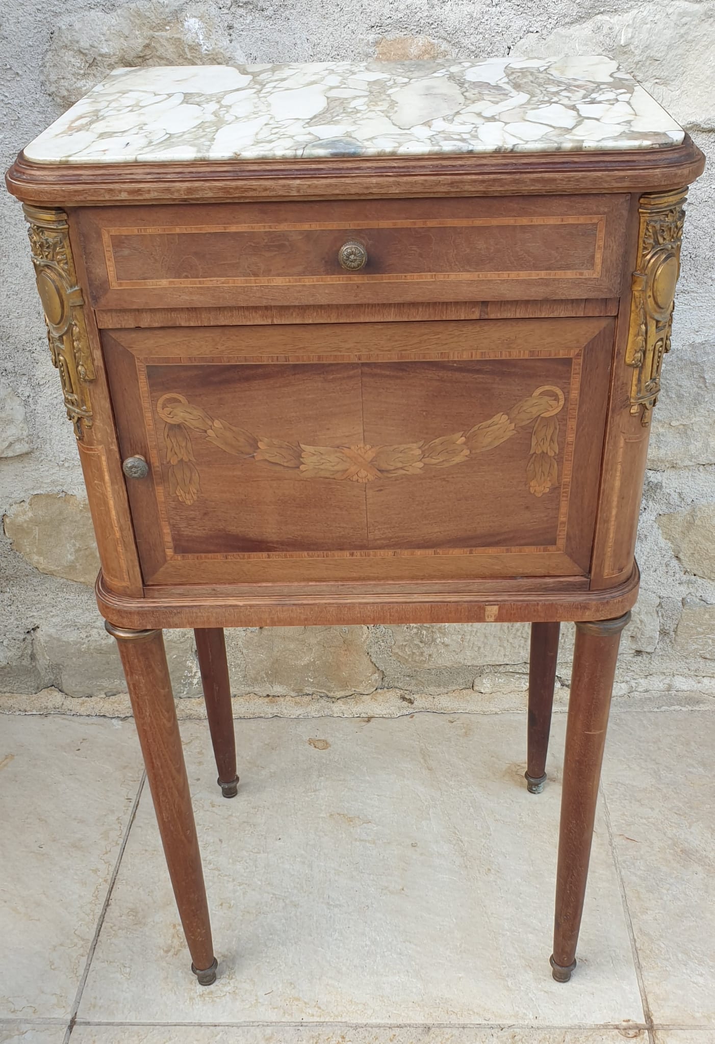 Old wooden bedside table on marble top