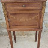 Old wooden bedside table on marble top
