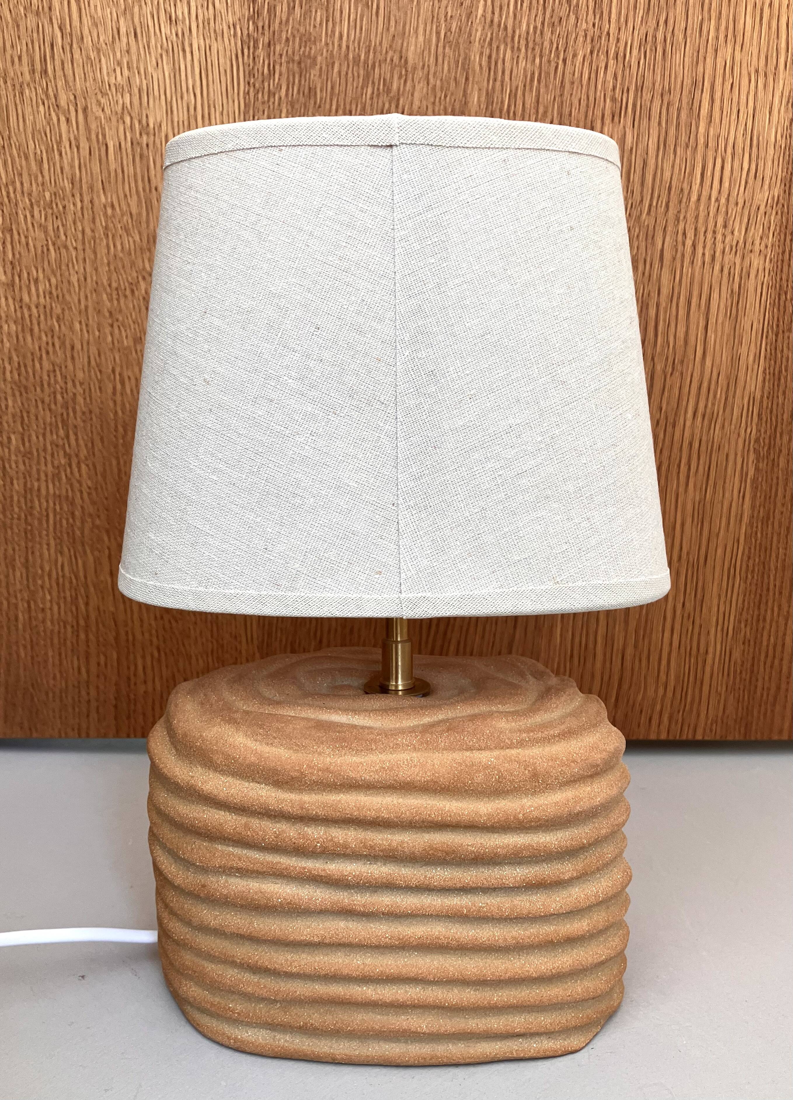 Oval table lamp in handcrafted ceramic with draped effect.