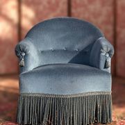 Vintage blue velvet frog chair, a timeless comfortable piece.