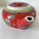 Vintage red Chinese teapot decorated with dragons and symbols.