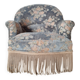 Antique floral velvet armchair with fringes.