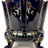 Large earthenware pot cover with enamelled decoration on a blue oven background
