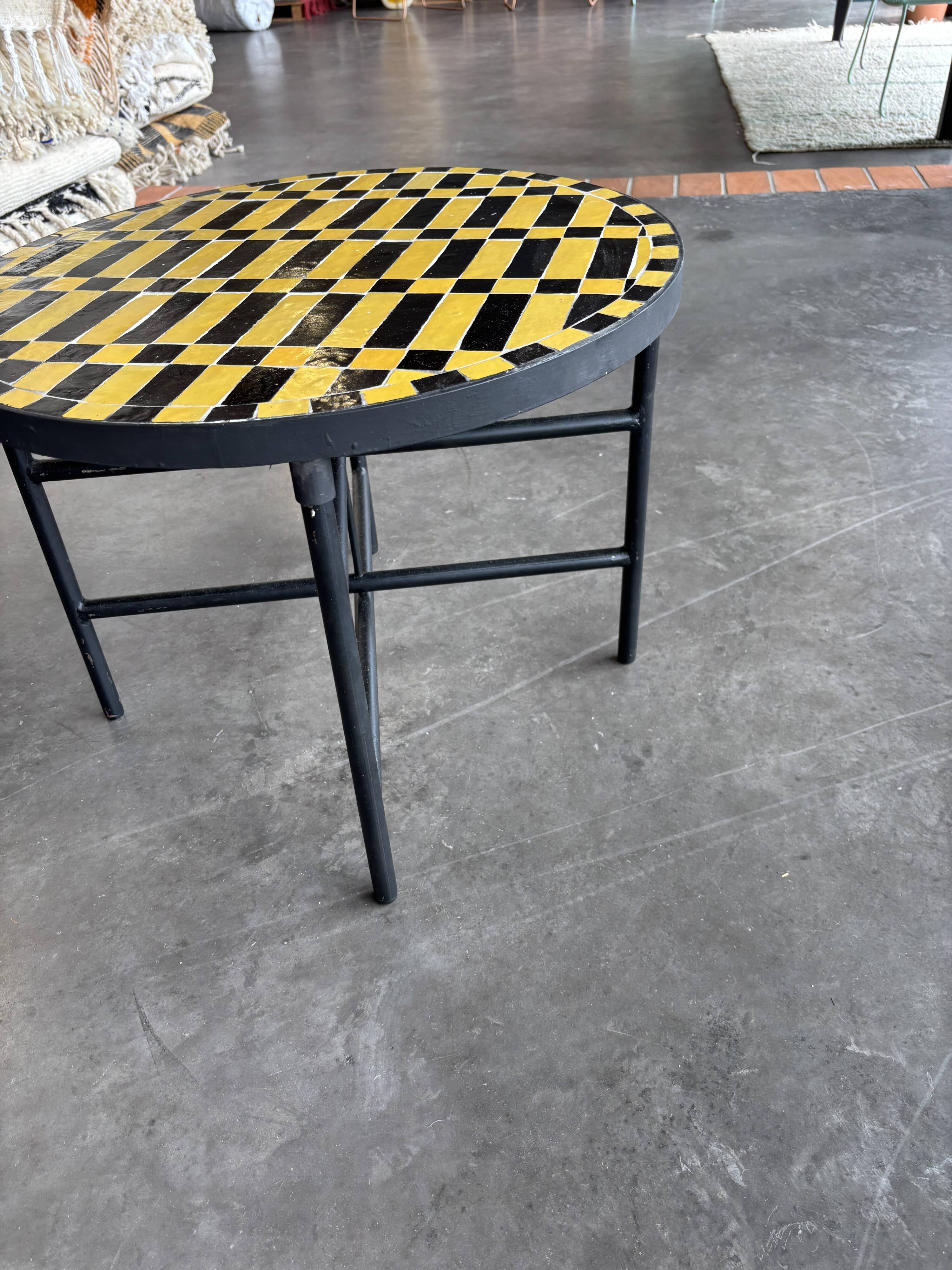 Round coffee table in yellow and black zellige, Moroccan graphic pattern.