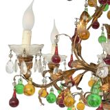 Lustrous chandelier with two wall lights decorated with foliage and pendants.