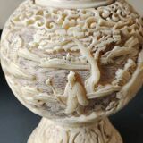 Asian-inspired ball vase. In beige cinnabar lacquer. Scenes of life decor. Arabesque and floral friezes. Height 24 cm