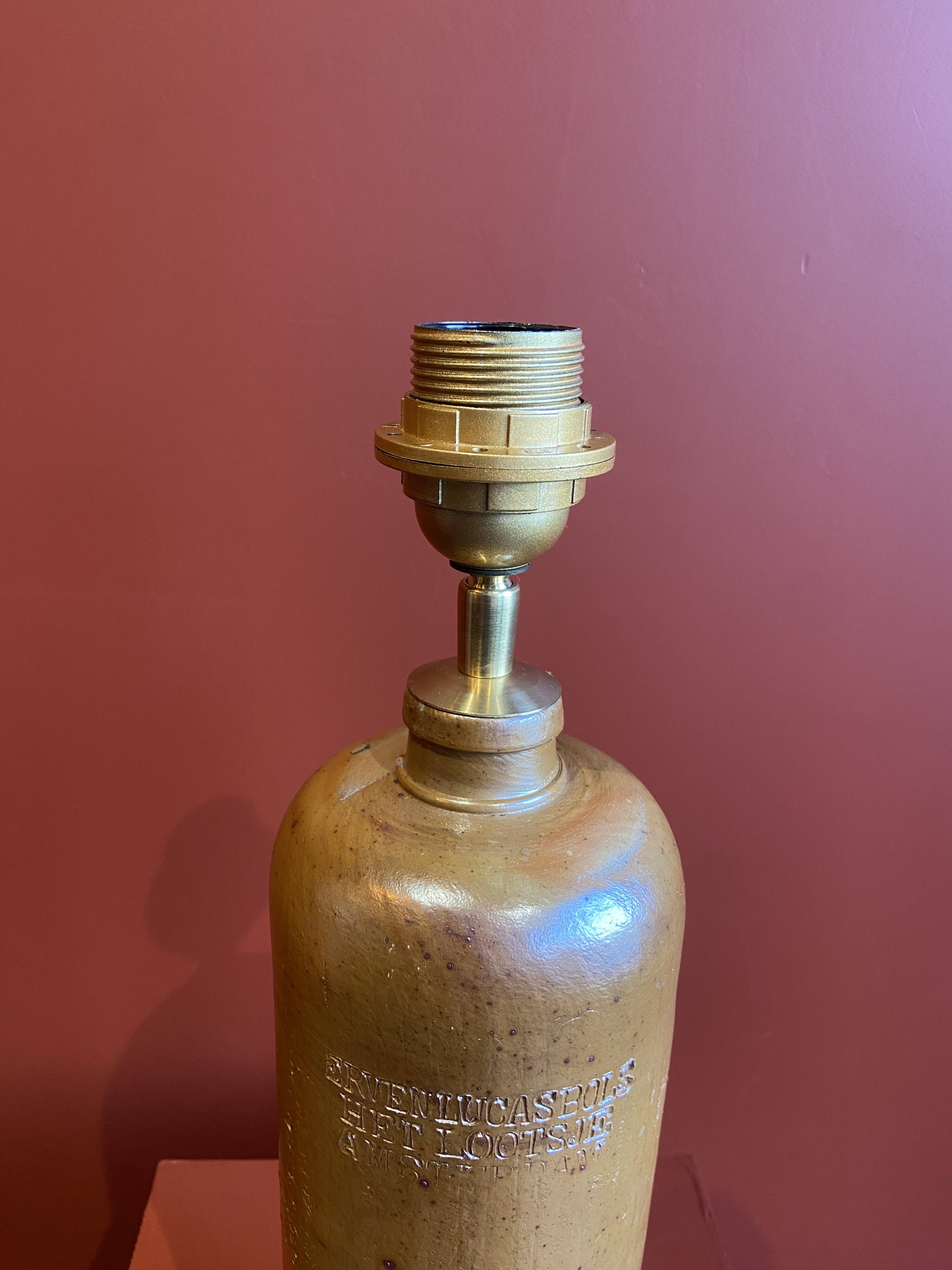 "Stoneware Bottle Lamp" with a multicoloured blue lampshade handwoven in India.