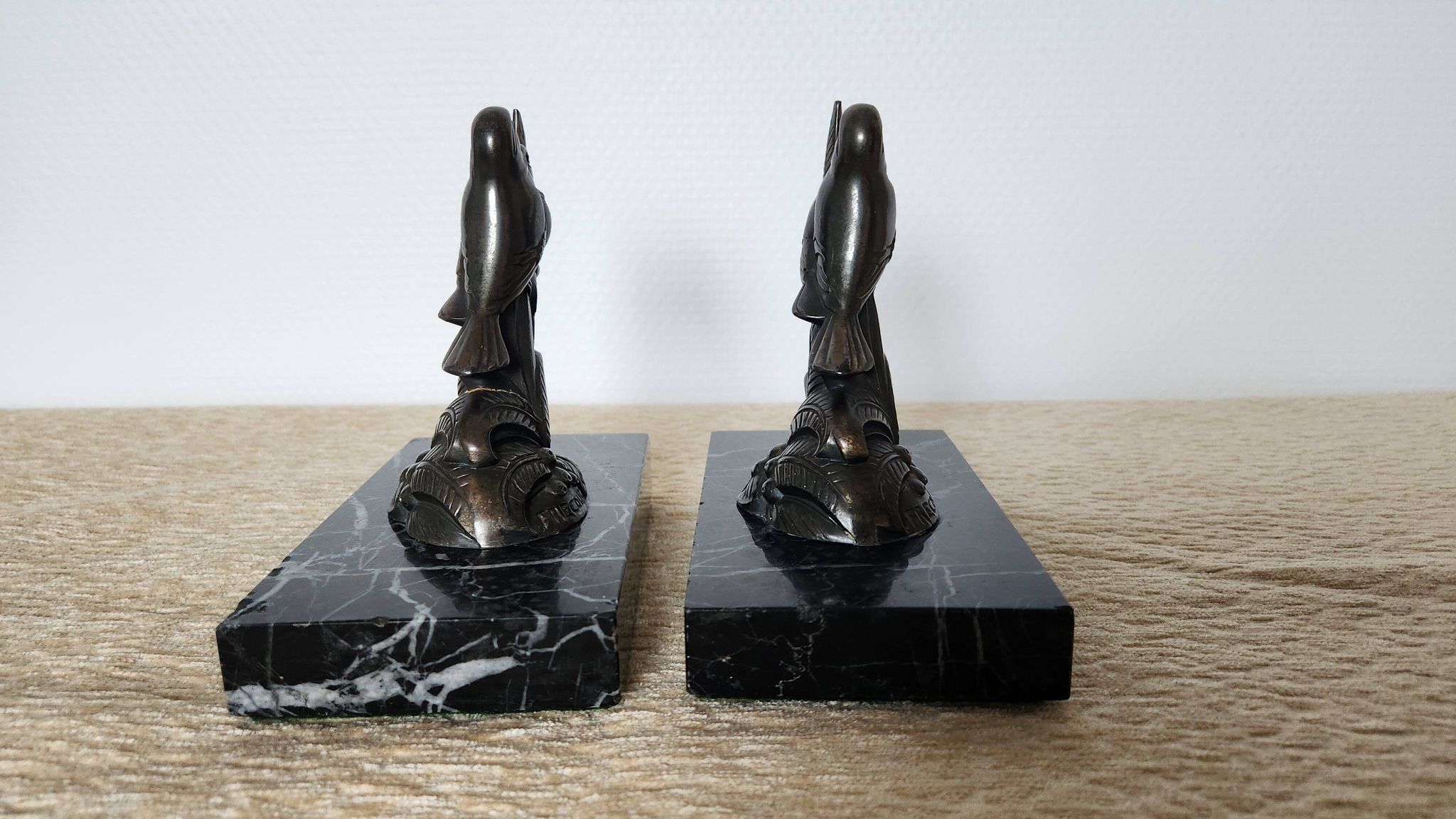 Pair of Art Deco bookends signed Frécourt, patinated metal & black marble