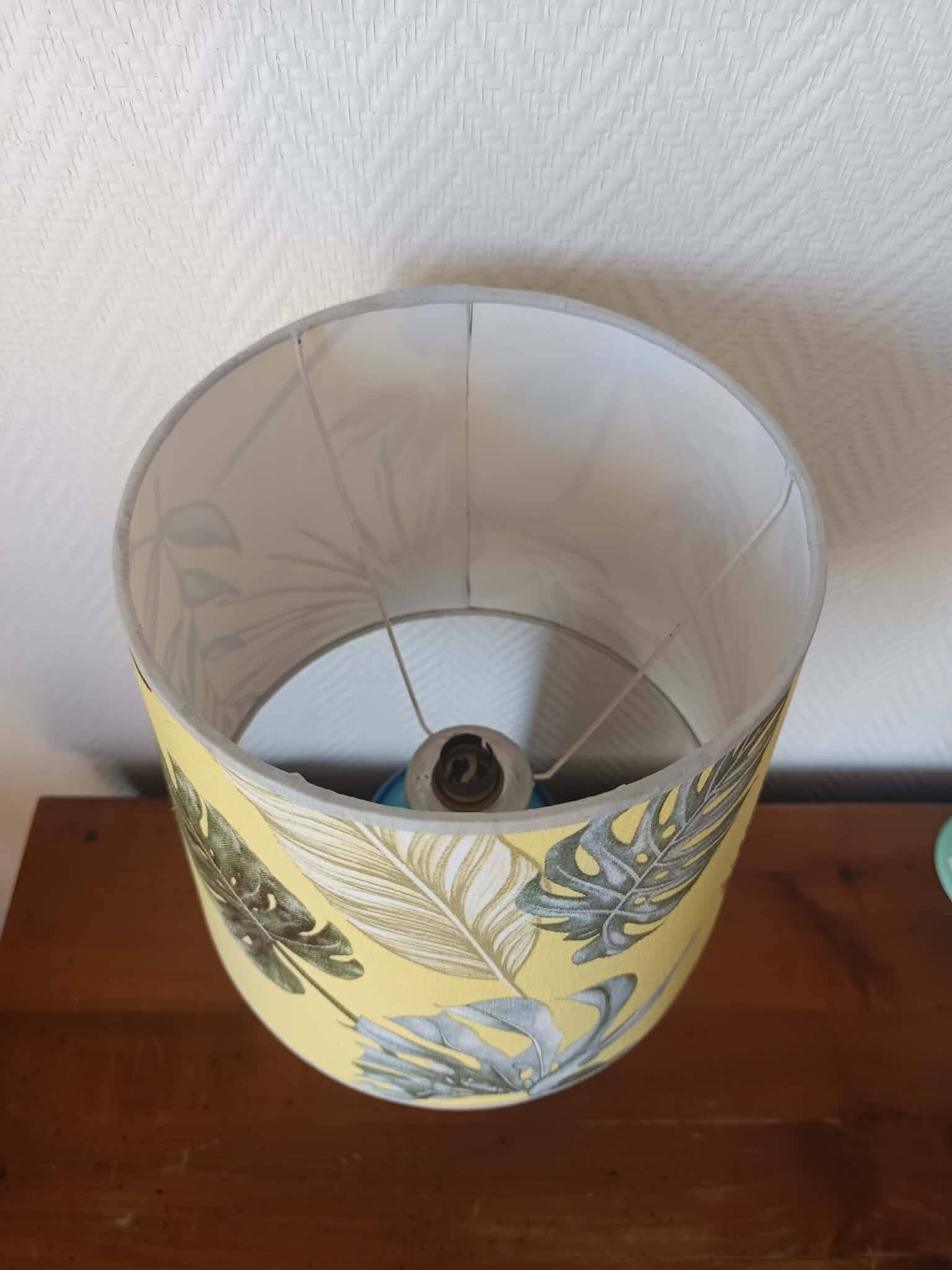 Blue ceramic lamp with claw feet and foliage lampshade.