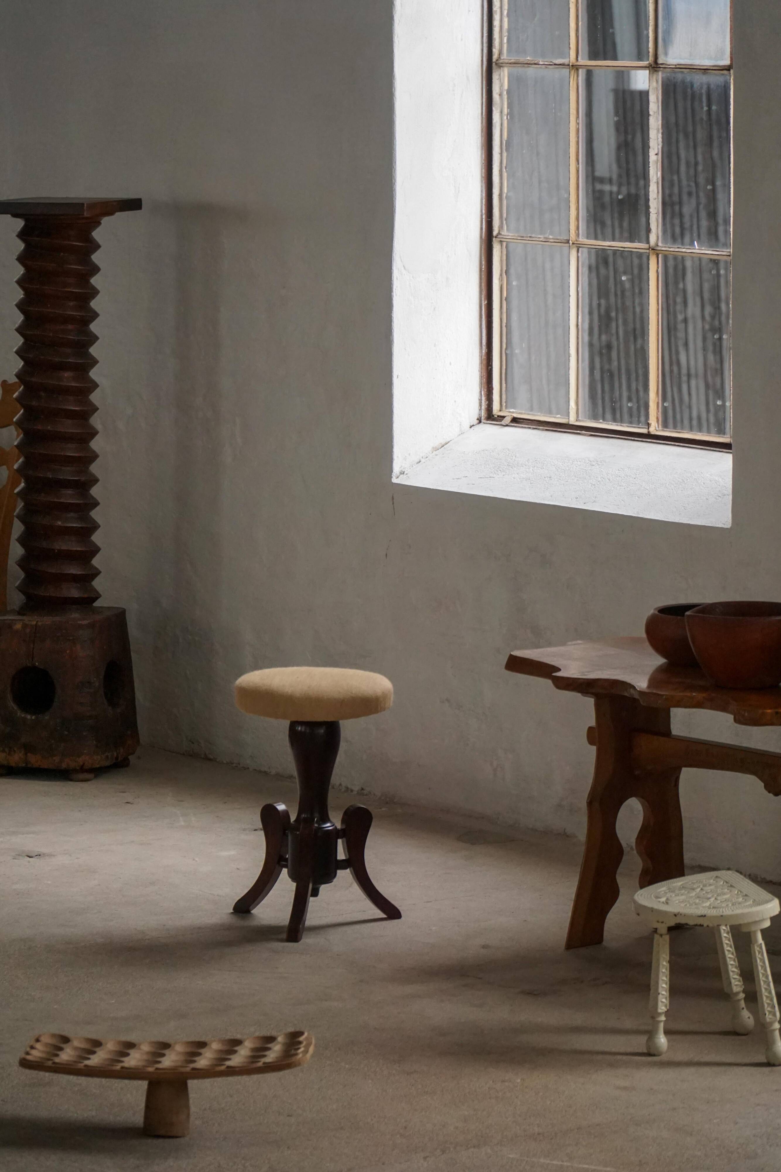 Adjustable Victorian-style piano stool with a jute fabric seat, early 20th century.