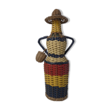 Old bottle dressed in scoubidou style rattan