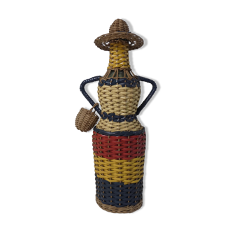 Old bottle dressed in scoubidou style rattan