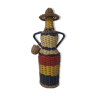 Old bottle dressed in scoubidou style rattan