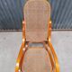 Curved wooden rocking chair with wicker cane rattan.