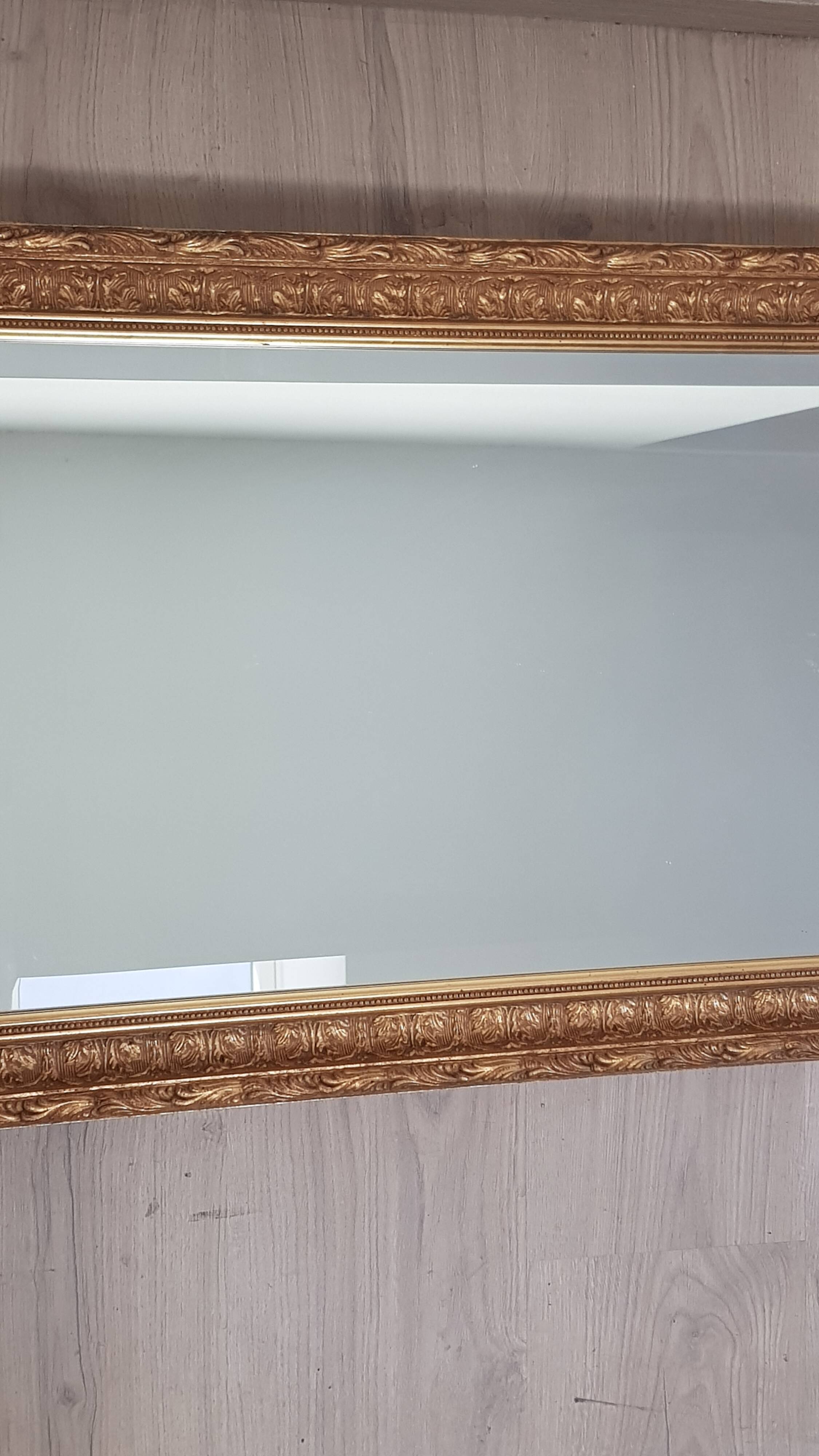 Mirror in gilded stucco wood and beveled glass