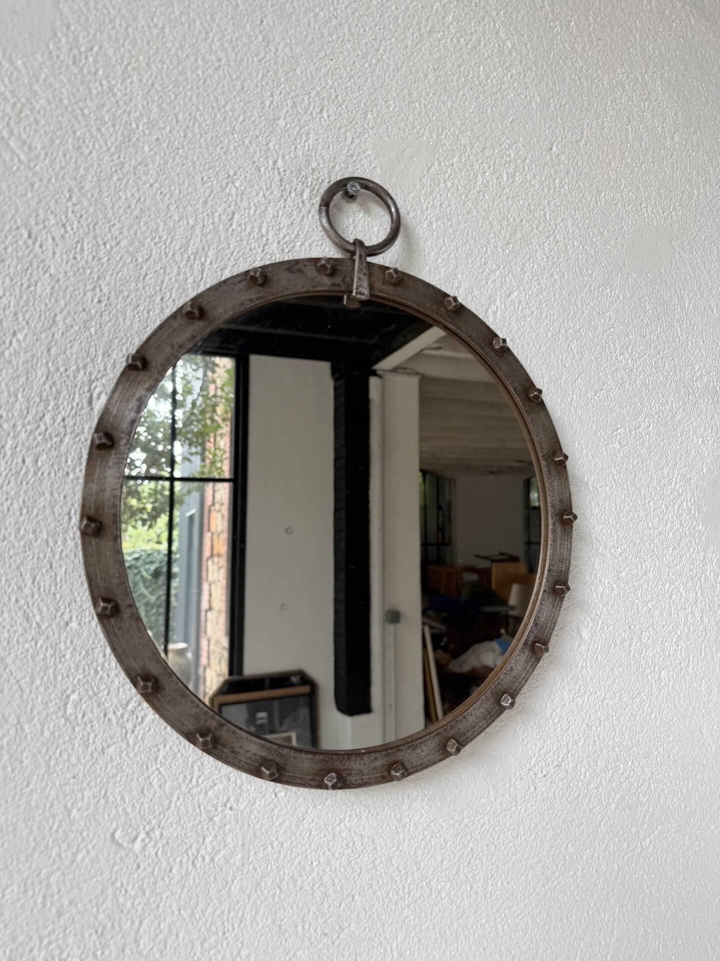 Brutalist round mirror with wrought iron and studs.