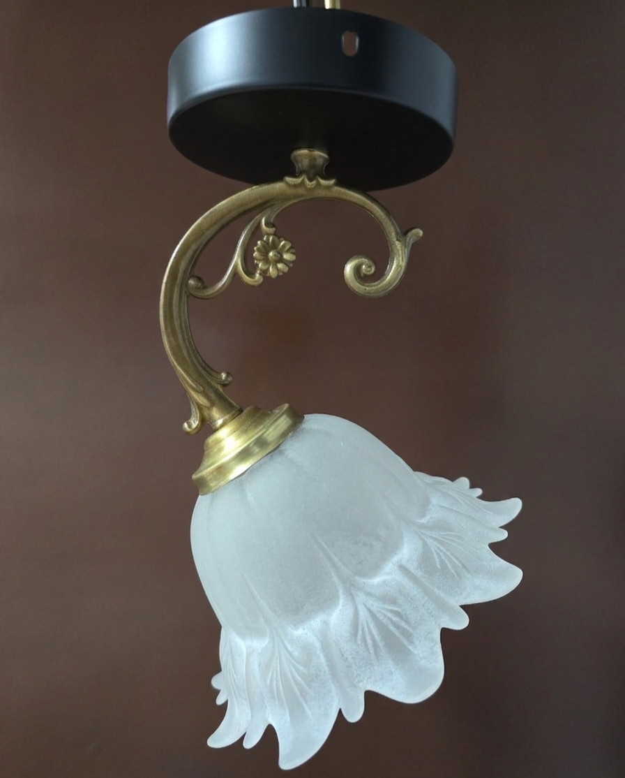 Frosted glass tulip wall sconces with brass arms.