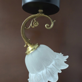 Frosted glass tulip wall sconces with brass arms.