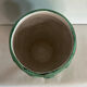 Vintage green patinated ceramic vase with raised floral decoration.
