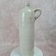 Antique beige glazed stoneware bottle from the 19th century, with a handle, vintage decor.