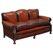 Restored Victorian sofa in leather with claw feet and feather cushions.