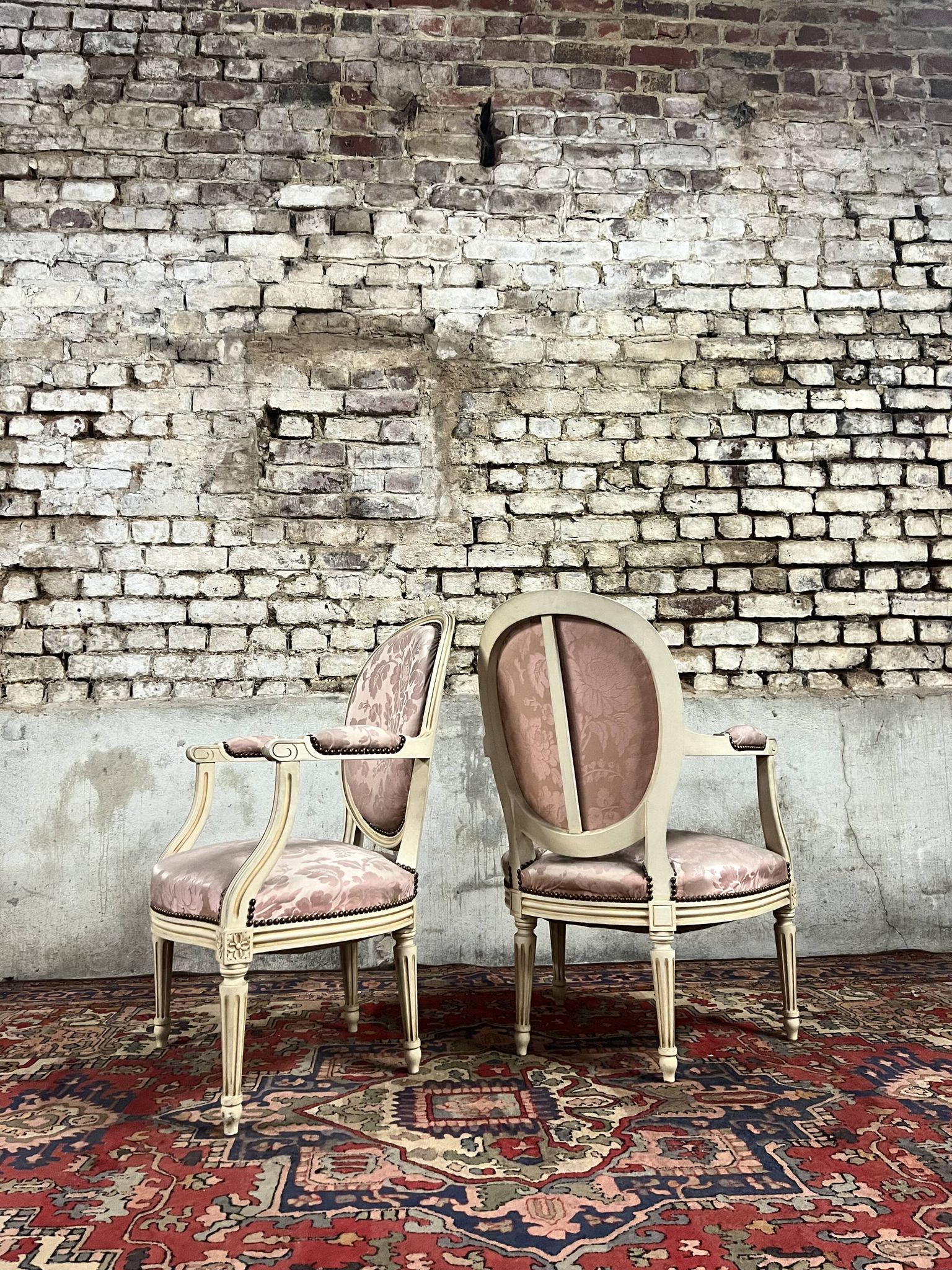 Paire de fauteuils dossier médaillon en bois laqué crème de style louis xvi