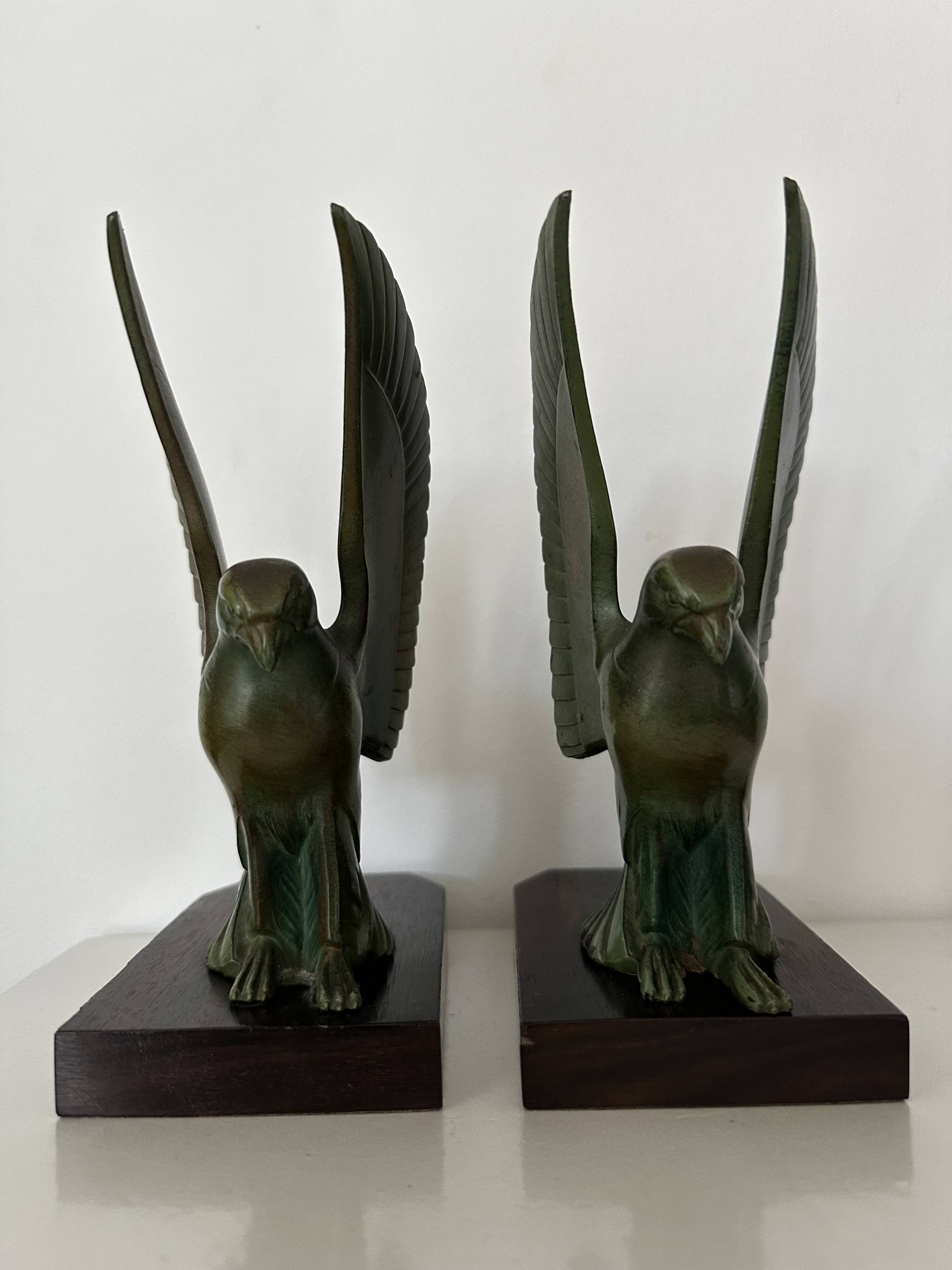 Pair of eagle bookends in green patina regula with rosewood base