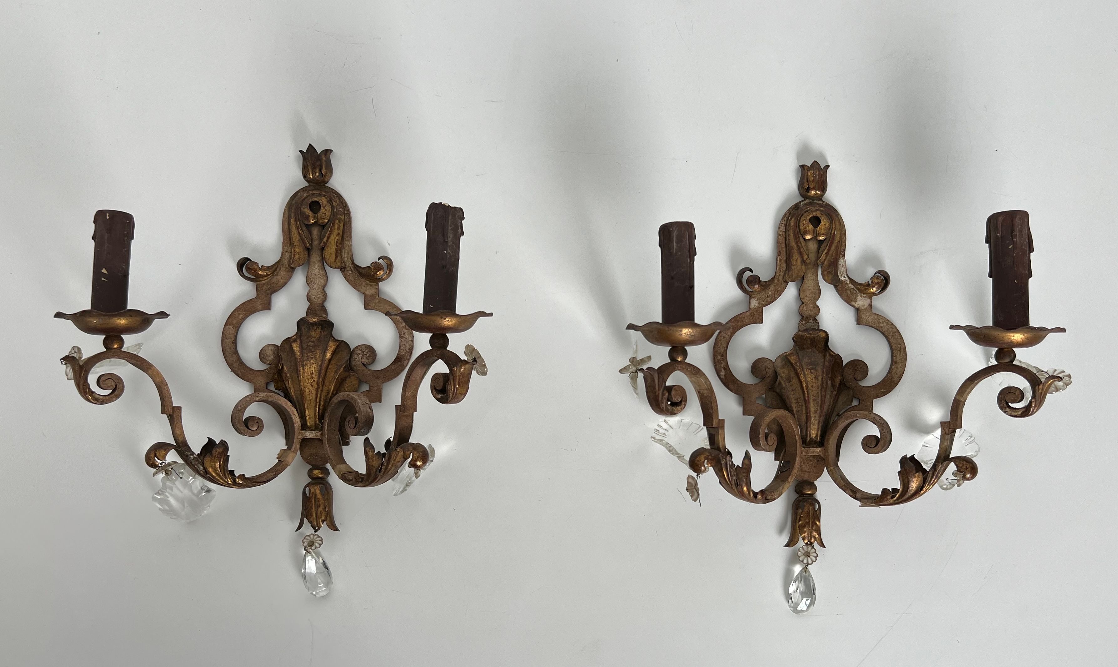 Pair of patinated wrought iron wall sconces with golden acanthus leaves and crystals.