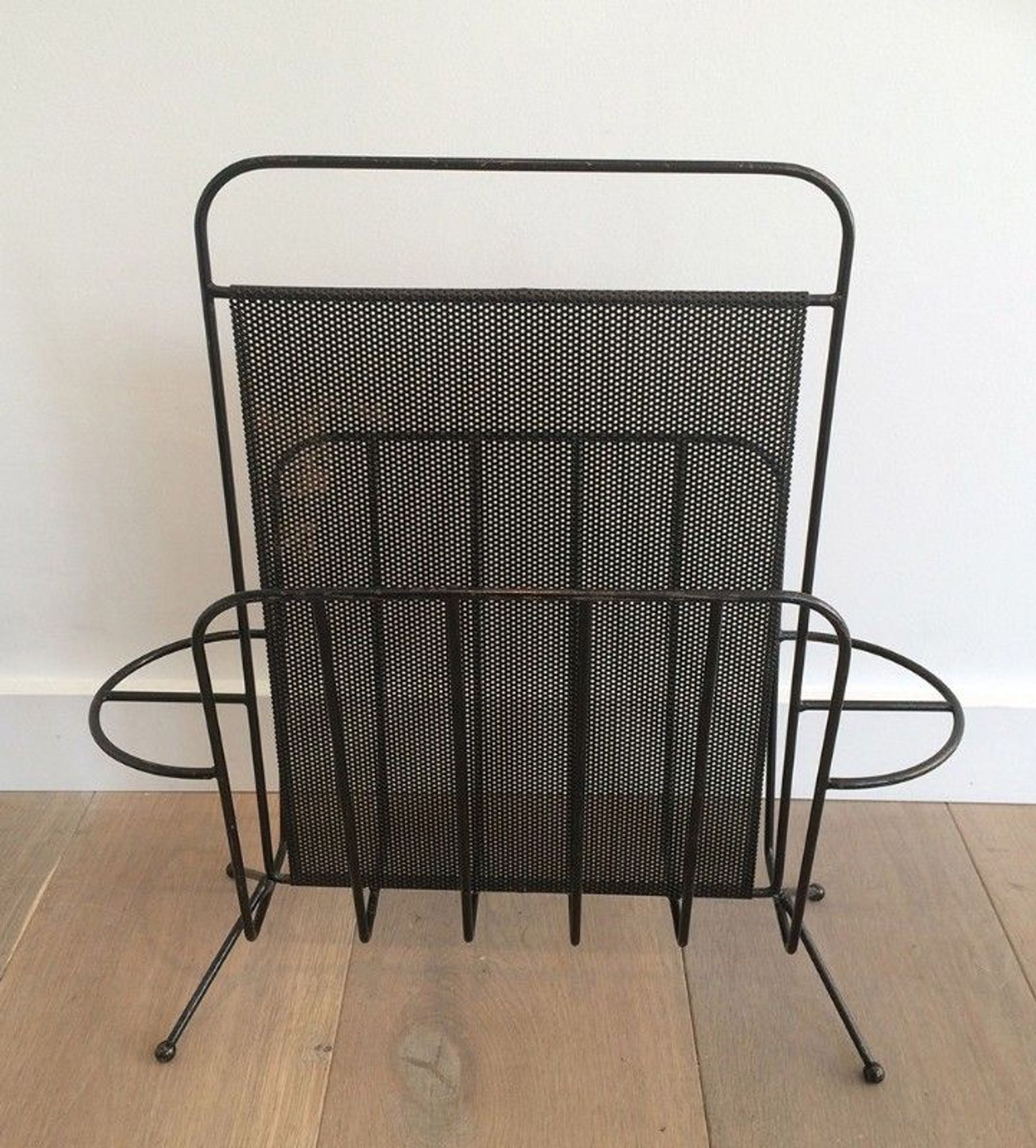Black lacquered metal and perforated metal magazine rack designed by Mathieu Matégot 50.