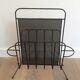 Black lacquered metal and perforated metal magazine rack designed by Mathieu Matégot 50.