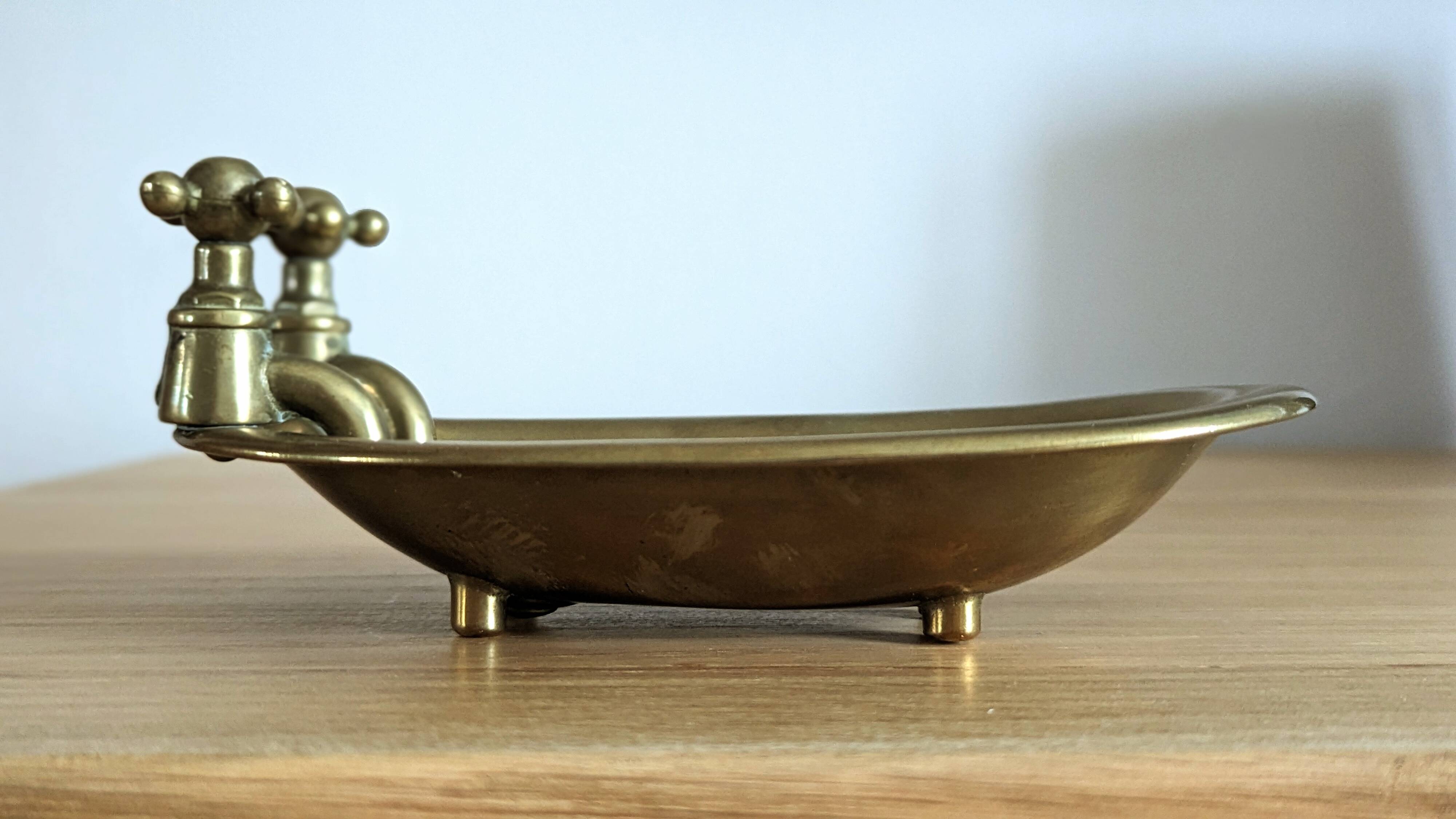 Old soap dish in the shape of a brass bathtub