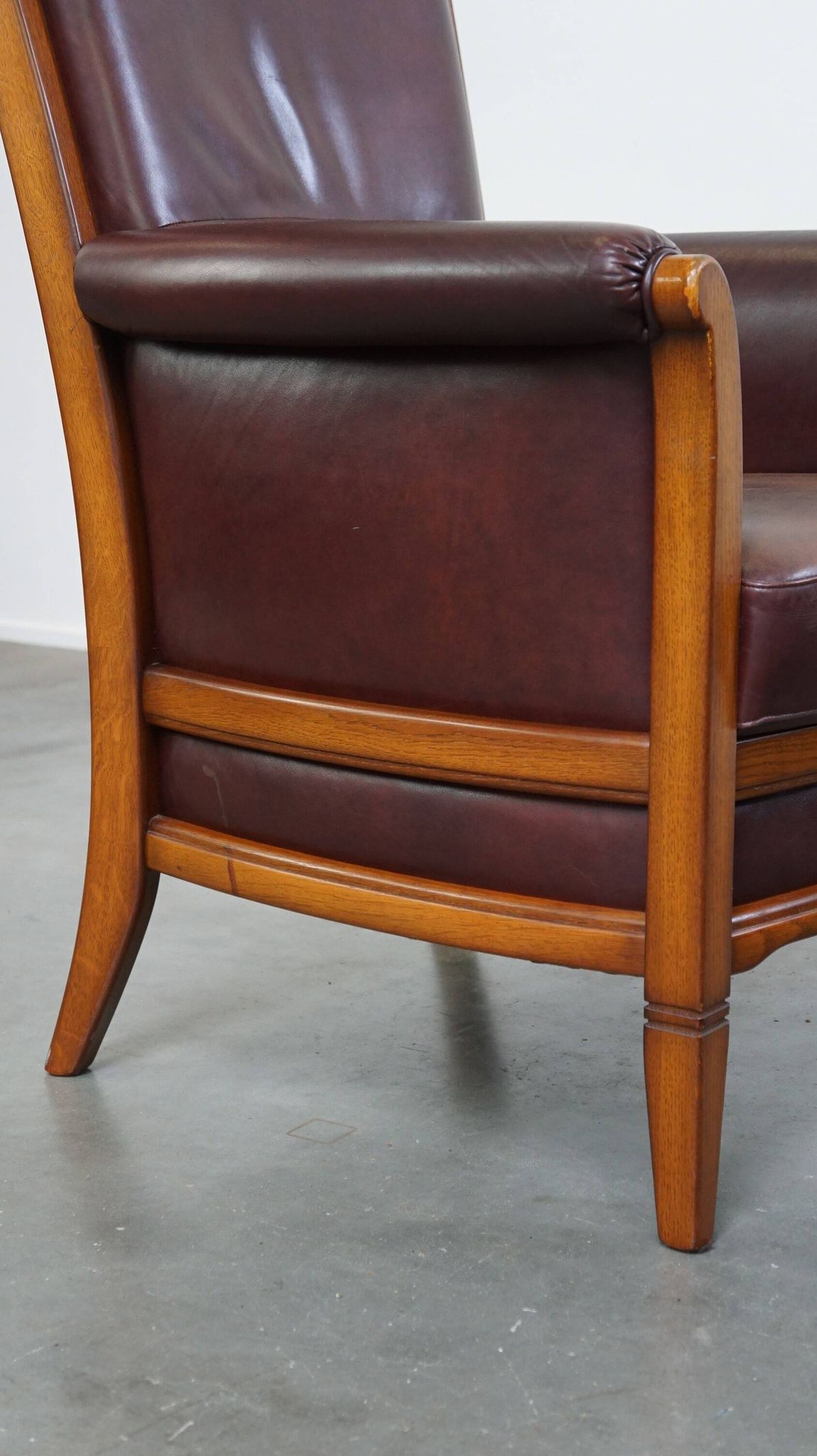 Very comfortable classic cowhide armchair with a high back in a mild Art Deco style