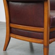 Very comfortable classic cowhide armchair with a high back in a mild Art Deco style