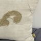 Cushion in vintage fabric with ornamentation.