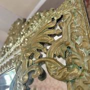 A wall mirror in the Louis XVIII style.