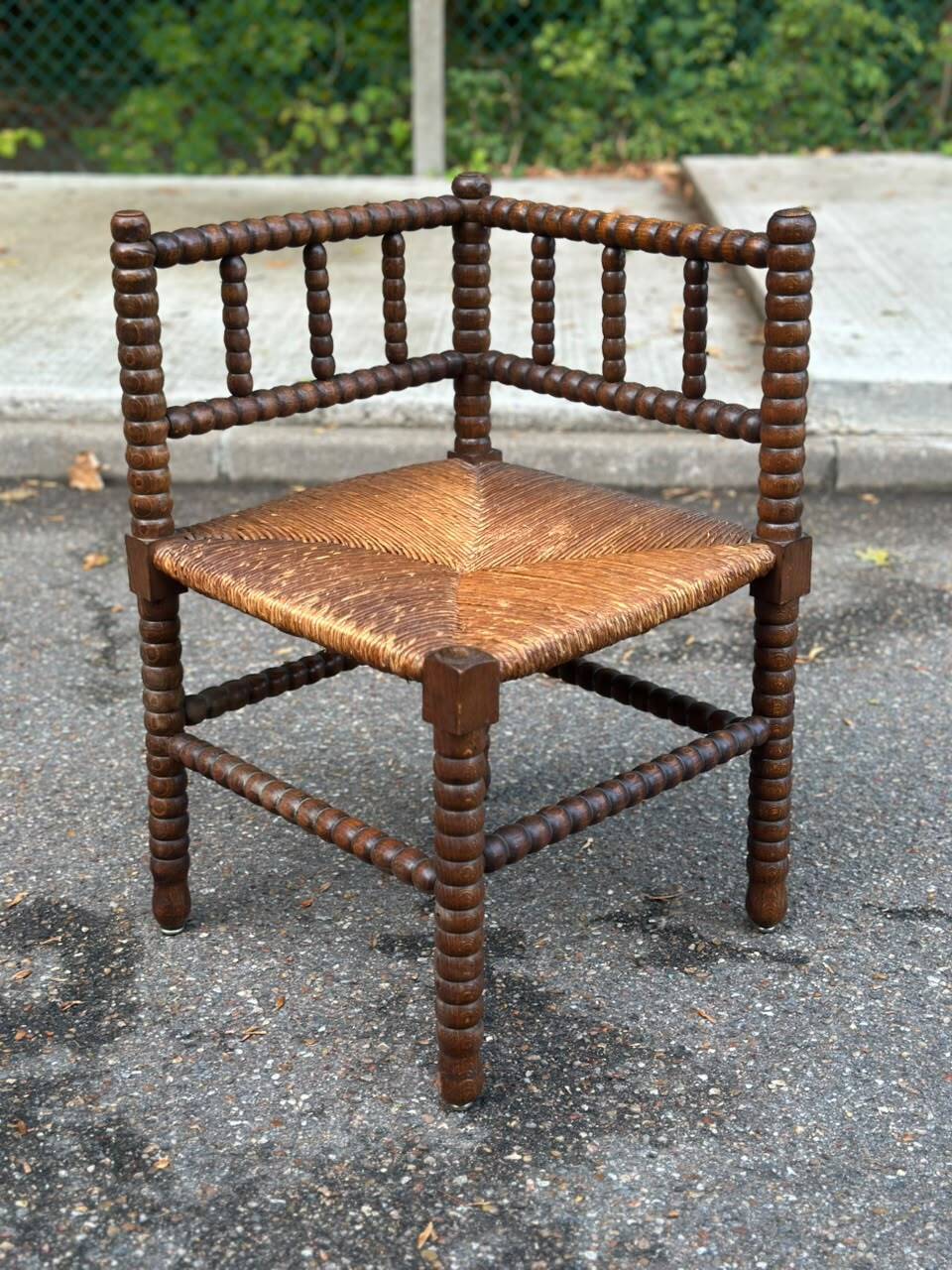 Brutalist corner chair in turned wood with straw bobbins, 1960.