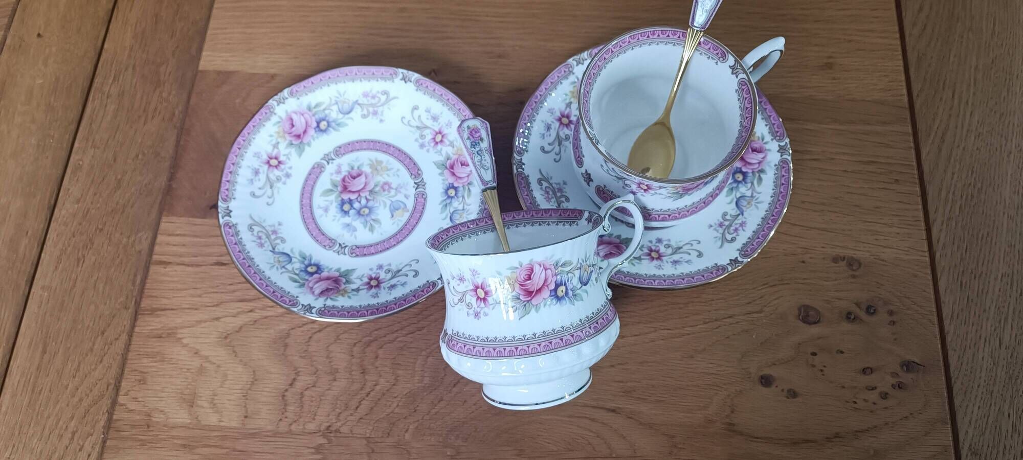 Duo of English porcelain tea cups from Queen's Richmond and spoons.