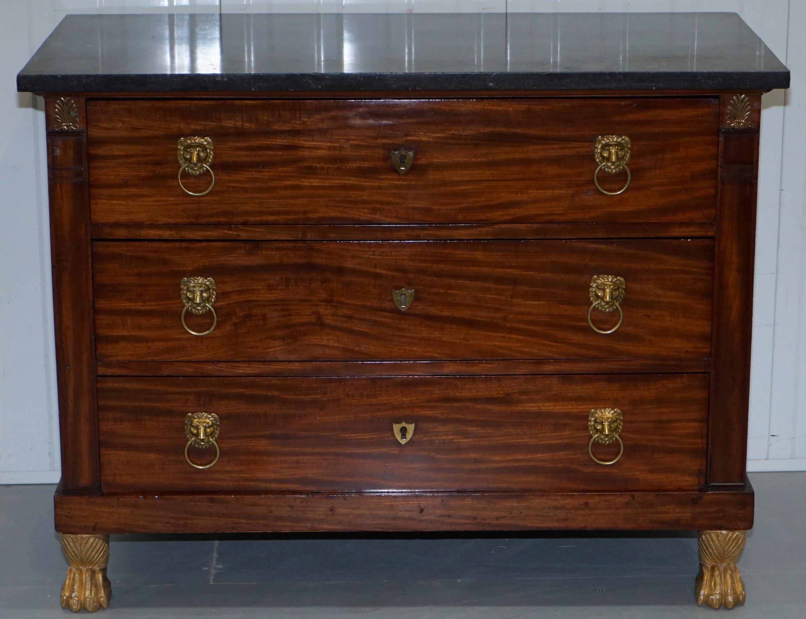 19th-century Empire commode with a marble top and lion paw feet.