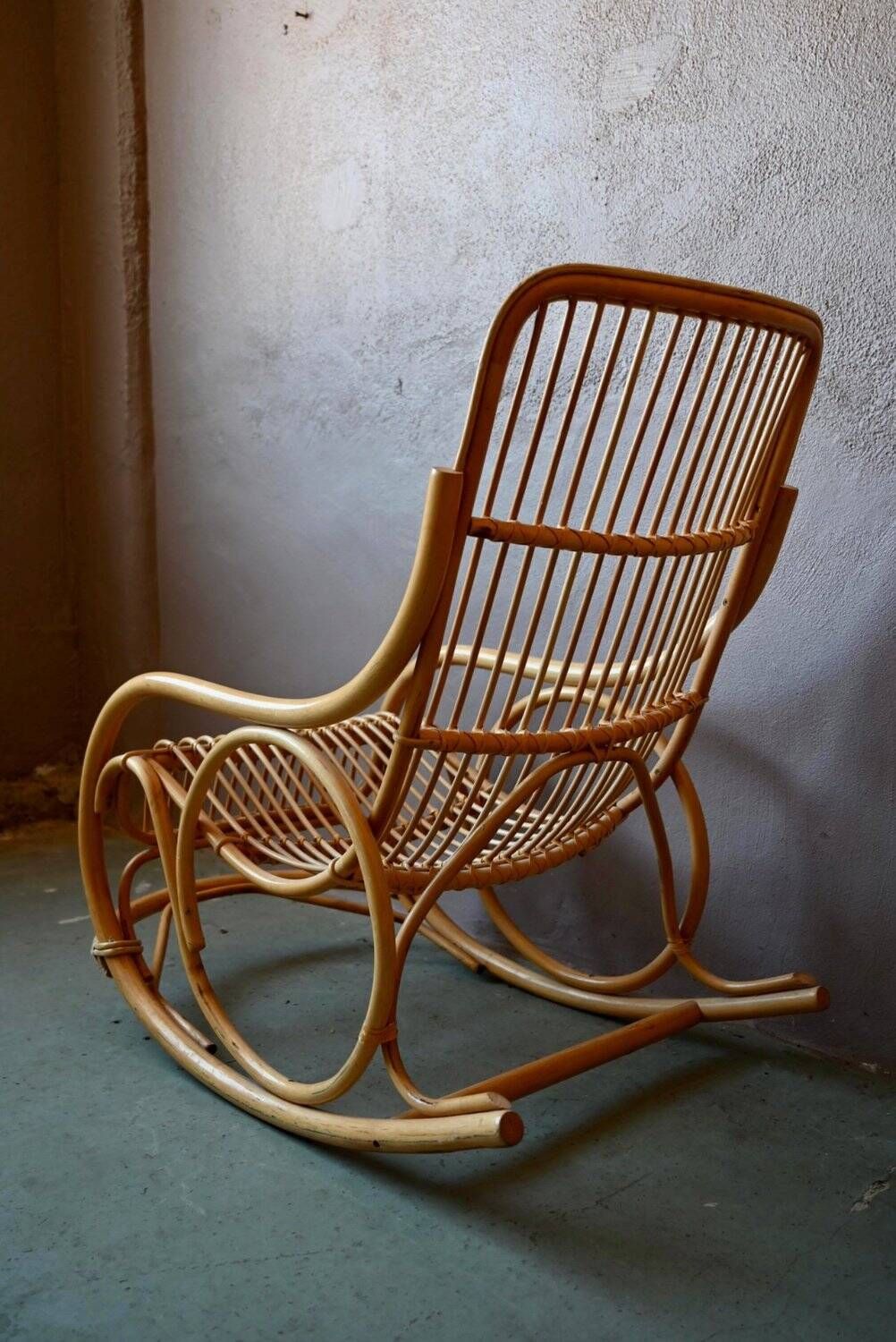 Vintage rocking chair in rattan from the 60s-70s, high openwork backrest.