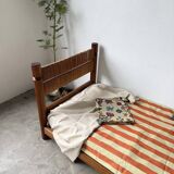 Brutalist style bed with chain and straw