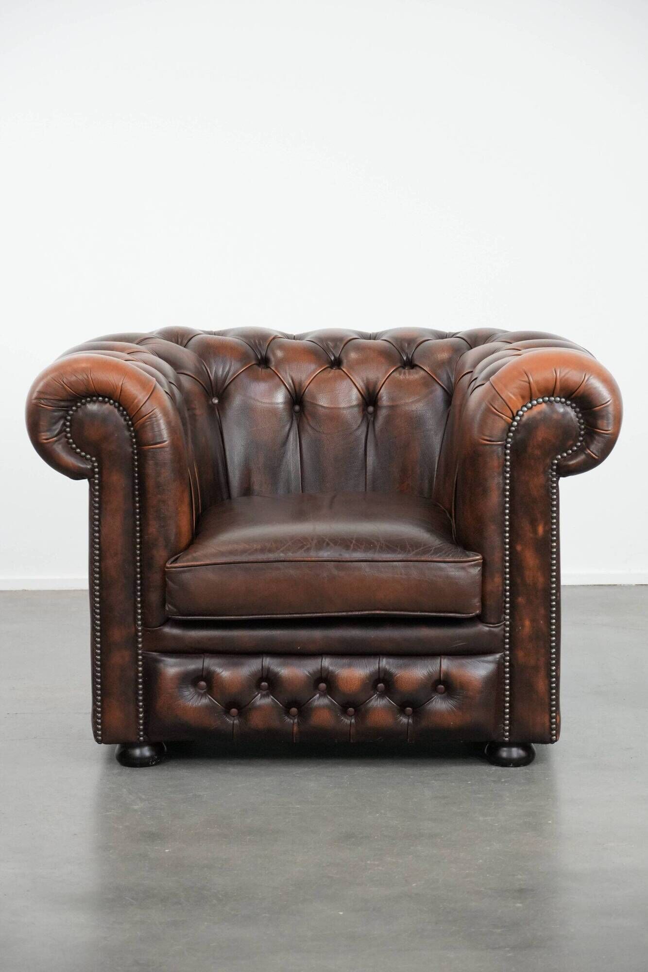 Brown Chesterfield armchair made of cowhide leather in English style