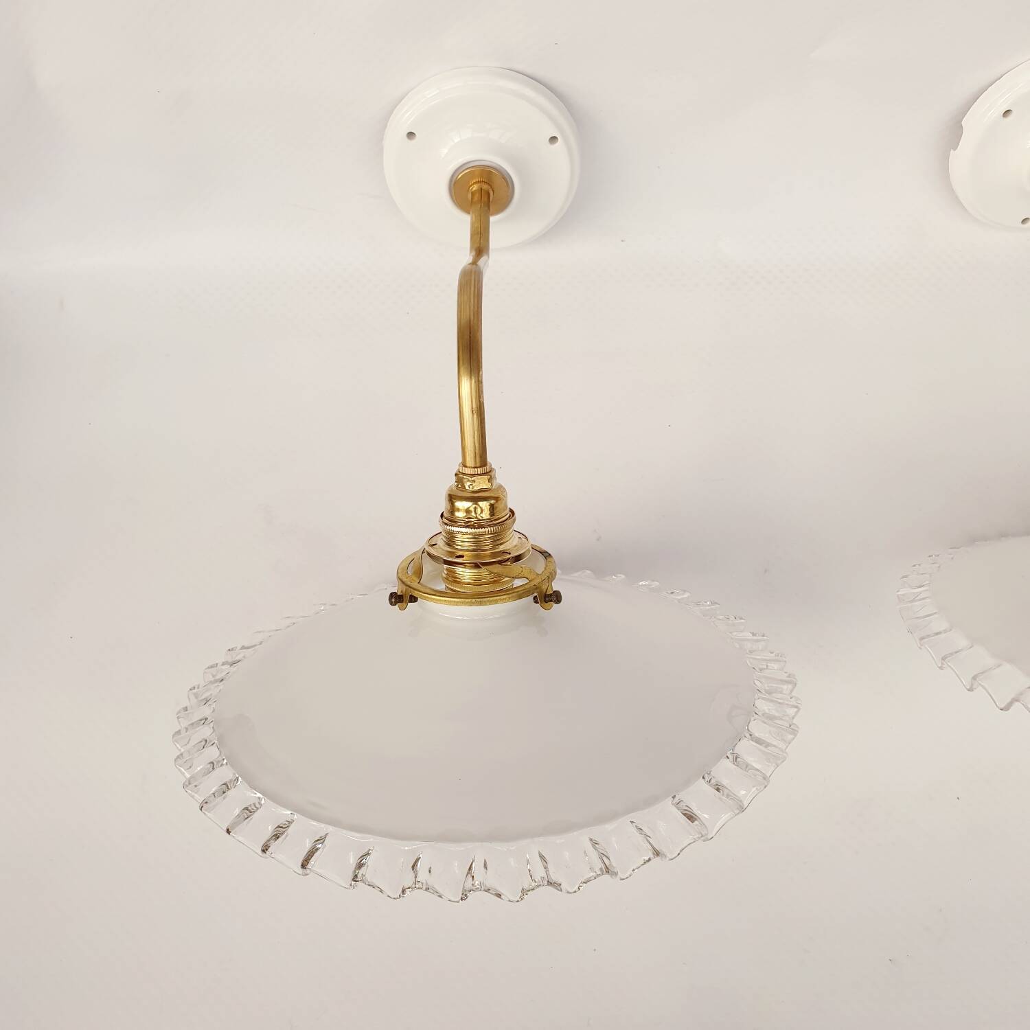 Swan neck sconces in serrated opaline