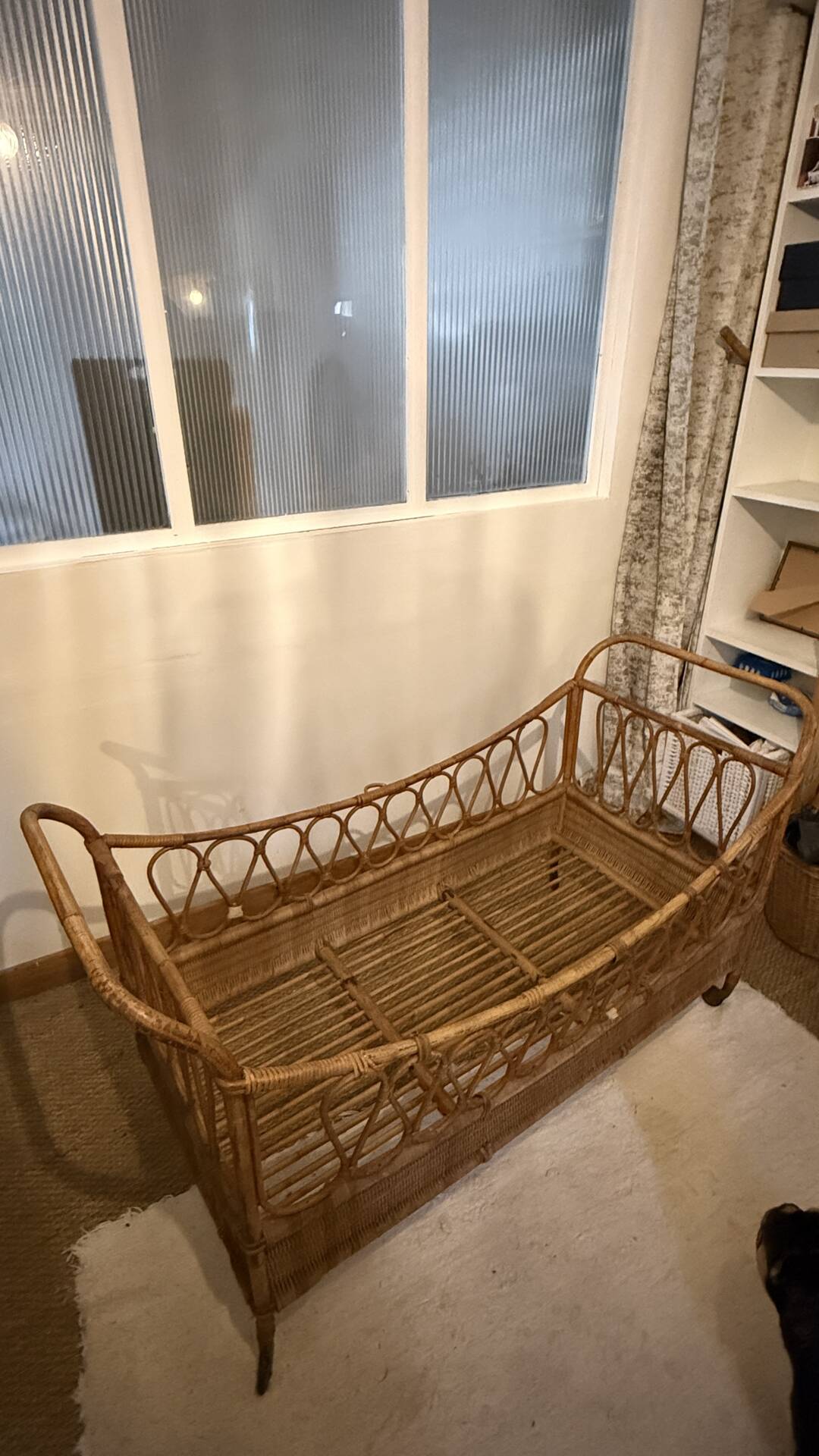 Vintage rattan baby cot on wheels.