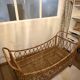 Vintage rattan baby cot on wheels.